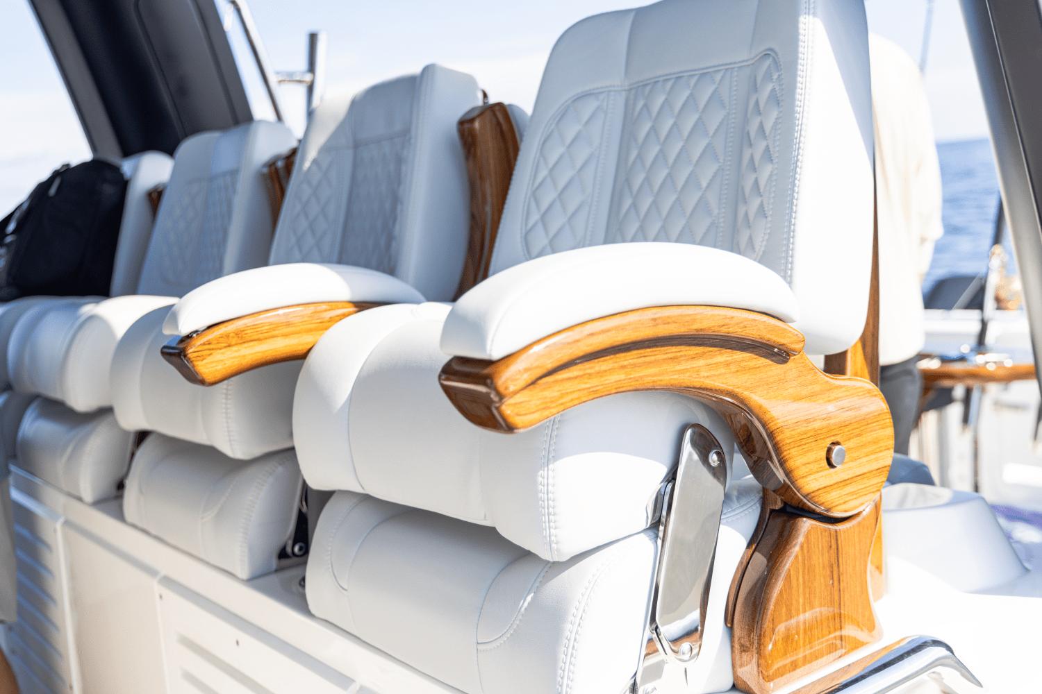 Slide: The Image of Luxury seating on 2024 Aquila 47 Molokai yacht with white leather and wooden armrests. - 28