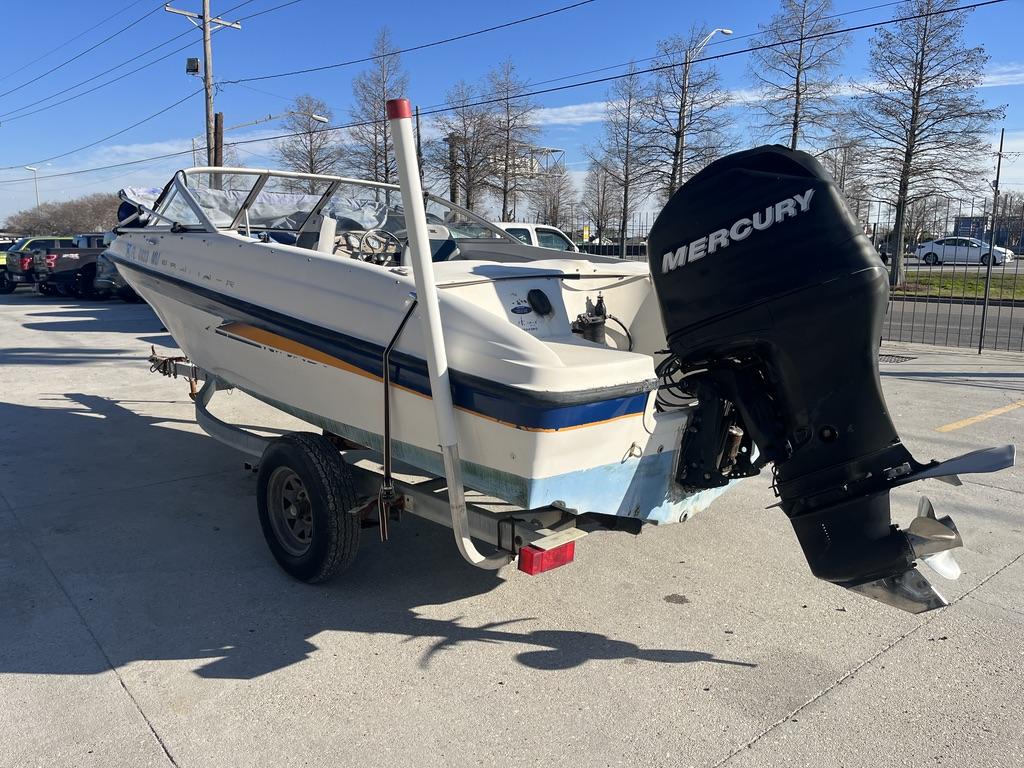 Slide: The Image of 2004 Bayliner 175 boat with Mercury outboard motor on trailer, parked outdoors. - 10