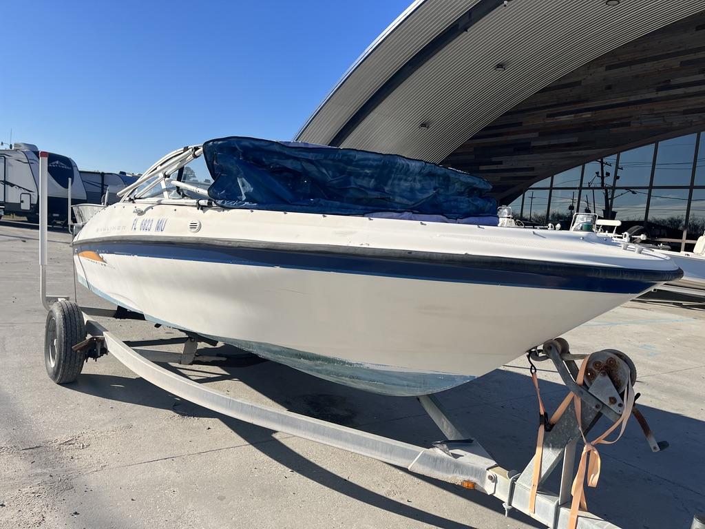 Slide: The Image of 2004 Bayliner 175 boat on trailer, parked outdoors near modern building. - 7