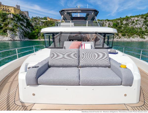 Slide: The Image of 2025 Beneteau Grand Trawler 62 yacht with luxurious deck seating, scenic coastal backdrop. - 20