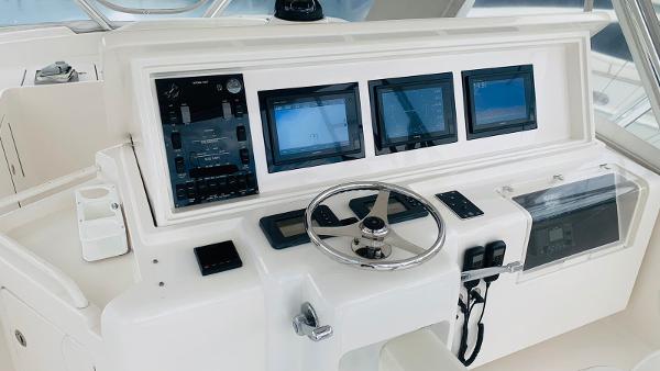 Slide: The Image of Control panel of a 2005 Bertram 570 yacht with multiple screens and steering wheel. - 4