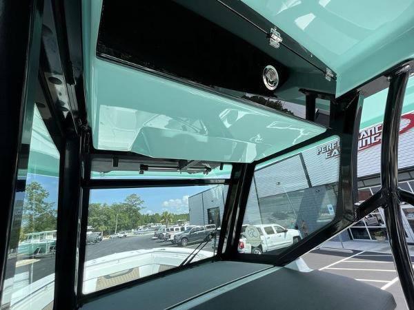 Slide: The Image of 2024 Blackfin 272 CC boat interior with overhead storage and exterior view. - 11