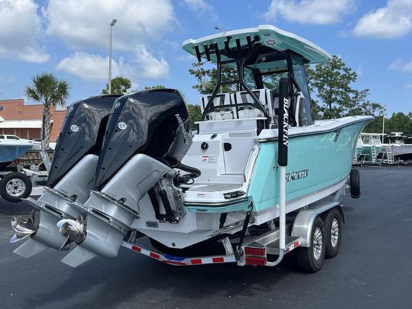 Slide: The Image of 2024 Blackfin 272 CC boat with dual outboard engines on a trailer. - 4