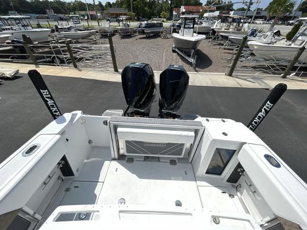 Slide: The Image of 2024 Blackfin 272 CC boat with dual outboard engines at a marina. - 6
