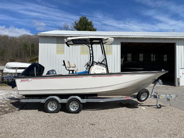Slide: The Image of 2023 Boston Whaler 210 Montauk boat on a trailer outside a storage building. - 5