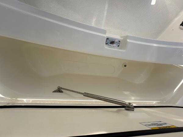 Slide: The Image of 2024 Boston Whaler 220 Dauntless storage compartment with hydraulic lift support. - 11
