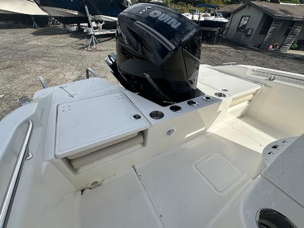 Slide: The Image of 2024 Boston Whaler 220 Dauntless boat with outboard motor, spacious deck, and storage compartments. - 2
