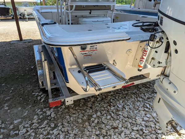 Slide: The Image of 2022 Carolina Skiff 21 SWS boat on trailer, rear view with ladder and outboard motor. - 2
