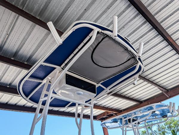 Slide: The Image of 2022 Carolina Skiff 21 SWS T-top under a metal roof. - 7