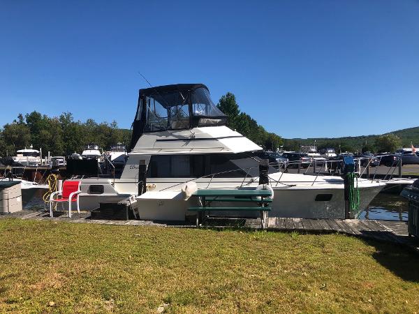Slide: The Image of 1983 Carver 32 Aft Cabin boat docked at a marina on a sunny day. - 1