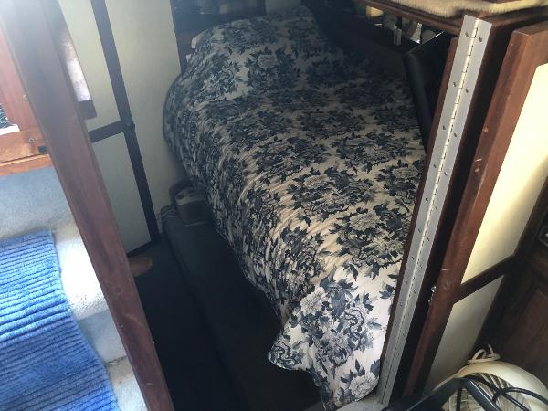 Slide: The Image of 1983 Carver 32 Aft Cabin interior with a cozy bed and floral bedspread. - 11