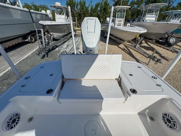 Slide: The Image of 2024 Caymas 28 HB boat interior with seating and storage, parked outdoors. - 11