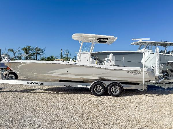 Slide: The Image of 2024 Caymas 28 HB boat on trailer, parked outdoors under clear blue sky. - 2