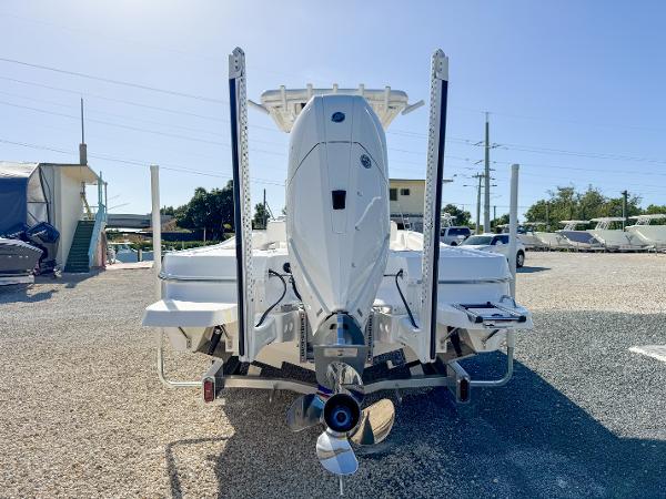 Slide: The Image of 2024 Caymas 28 HB boat, rear view, parked on gravel lot under clear sky. - 4