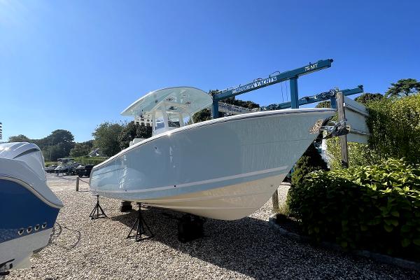 Slide: The Image of 2024 Cobia 262cc boat displayed on stands in a sunny outdoor setting. - 0