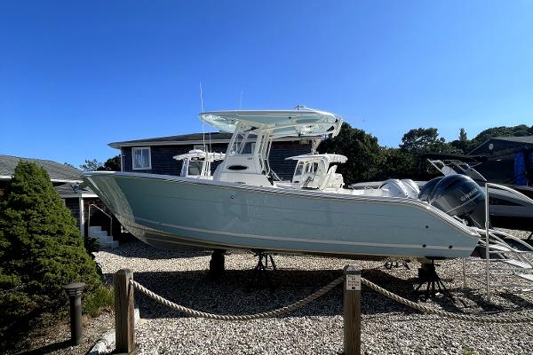 Slide: The Image of 2024 Cobia 262cc center console boat on display outdoors. - 1