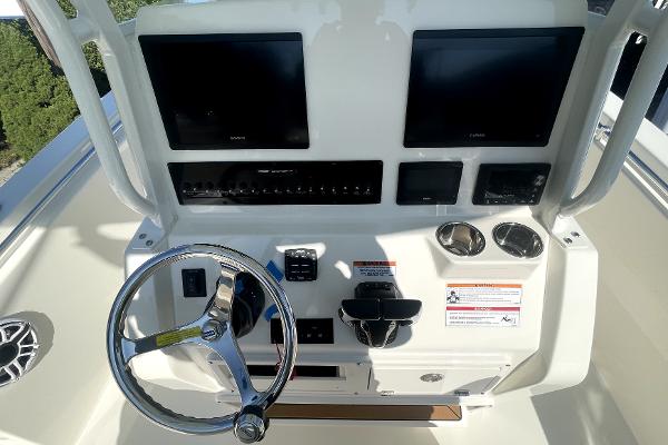 Slide: The Image of 2024 Cobia 262cc boat dashboard with dual screens and steering wheel. - 10