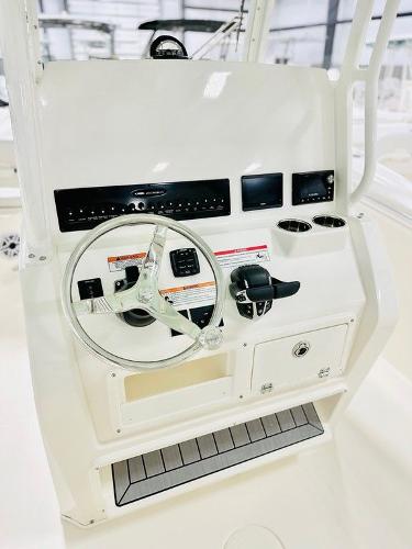 Slide: The Image of 2024 Cobia 262 CC boat console with steering wheel and controls. - 11