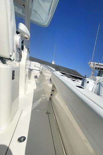 Slide: The Image of 2024 Cobia 262cc boat deck with white interior and clear blue sky. - 11