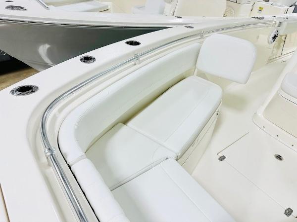 Slide: The Image of 2024 Cobia 262 CC boat interior with white seating and sleek design. - 12