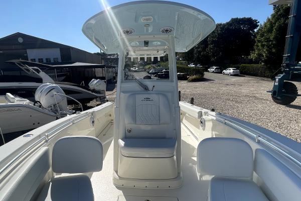 Slide: The Image of 2024 Cobia 262cc center console boat with seating and T-top in a marina. - 15