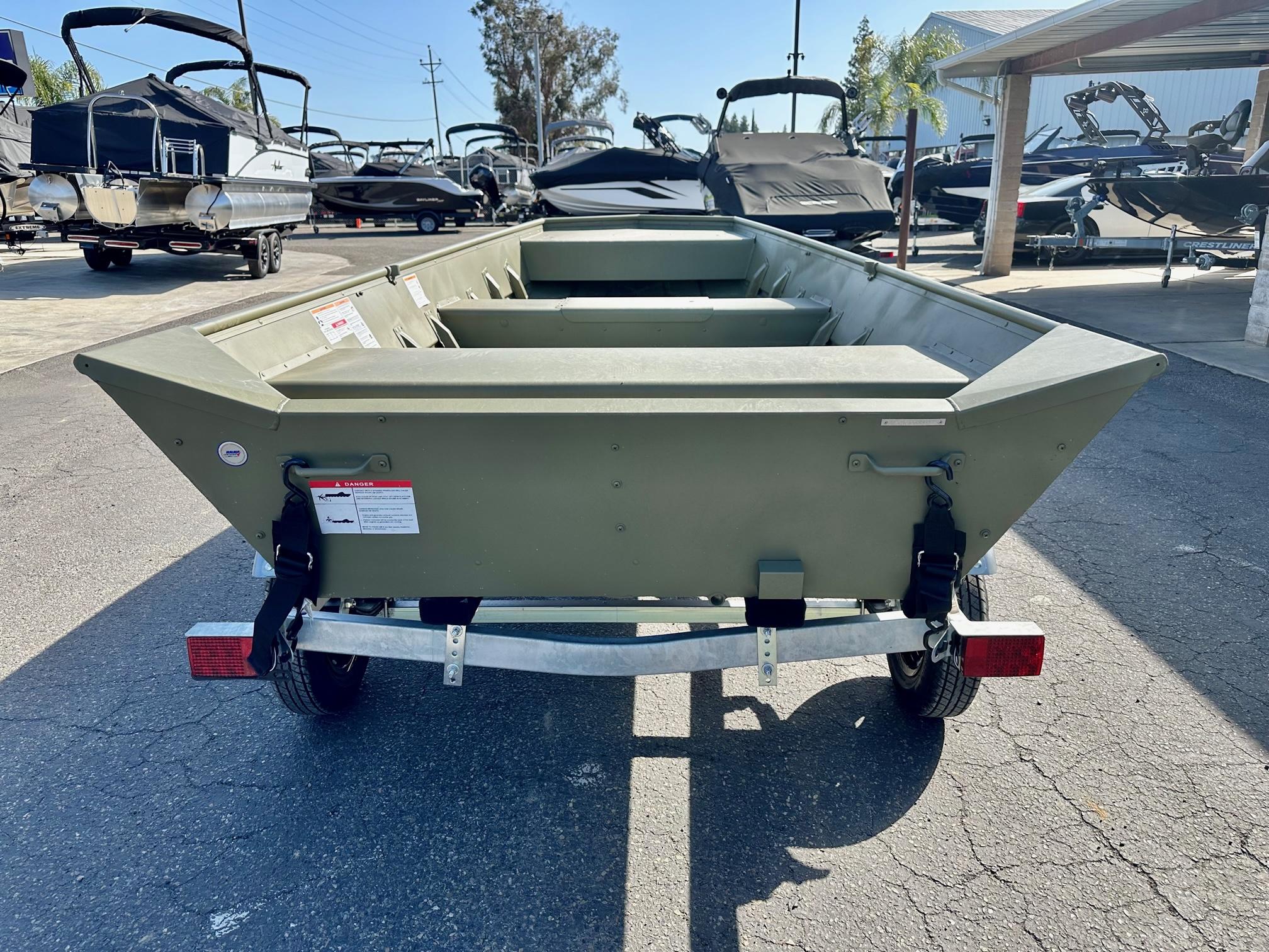 Slide: The Image of 2024 Crestliner 1448M boat on trailer, displayed at a dealership with other boats. - 7
