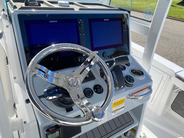 Slide: The Image of 2024 Crevalle 26 HCO boat dashboard with dual Simrad displays and stainless steel steering wheel. - 6