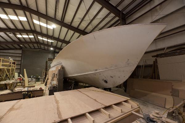 Slide: The Image of 2024 Custom Carolina 63 boat under construction in a large indoor facility. - 12