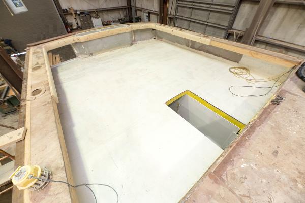 Slide: The Image of Custom Carolina 63 2024 boat under construction in a workshop. - 16