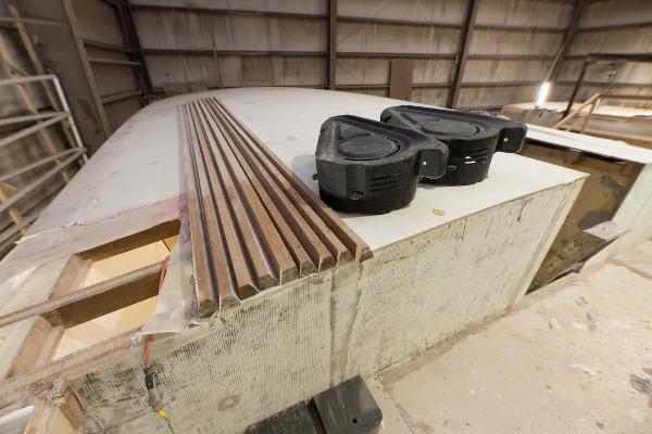 Slide: The Image of Custom Carolina 63 boat under construction, 2024 model, with wooden planks and equipment. - 36