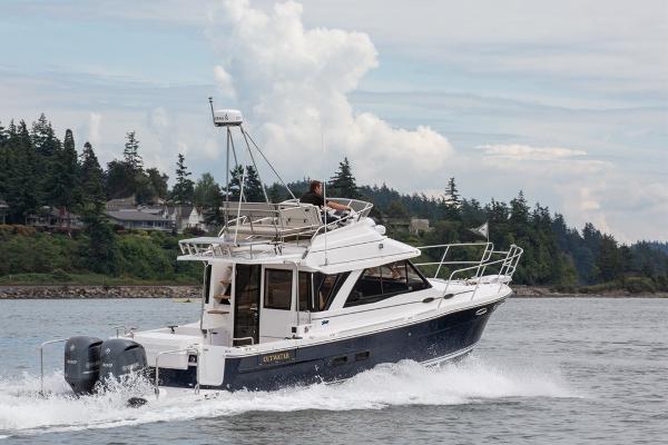 Slide: The Image of 2024 Cutwater 32 CB cruising on a scenic lake with forested shoreline. - 0