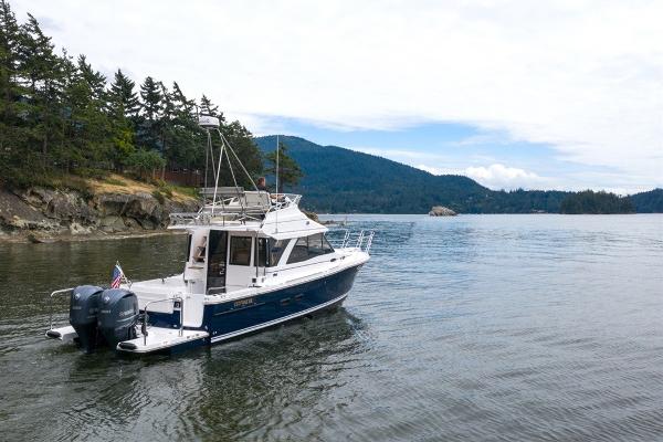 Slide: The Image of 2024 Cutwater 32 CB boat cruising in a scenic lake with forested hills. - 15