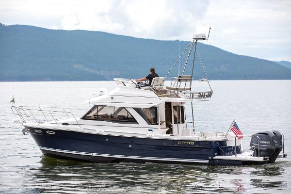 Slide: The Image of 2021 Cutwater 32 Command Bridge boat cruising on a serene lake. - 15