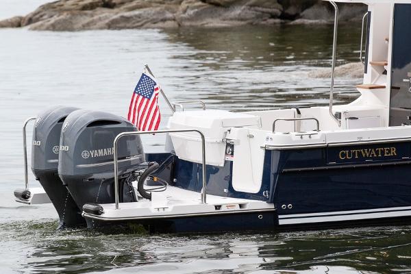 Slide: The Image of 2021 Cutwater 32 Command Bridge boat with Yamaha engines and American flag on water. - 16