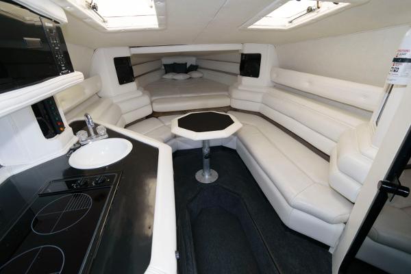 Slide: The Image of Interior of 1991 Fountain 38 Sport Cruiser with white leather seating and compact kitchen. - 10