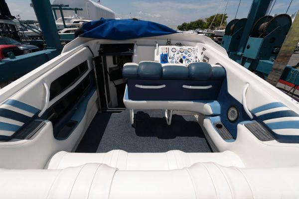 Slide: The Image of 1991 Fountain 38 Sport Cruiser interior with blue and white seating, docked at marina. - 3
