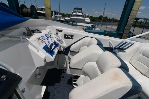 Slide: The Image of 1991 Fountain 38 Sport Cruiser cockpit with white and blue seating, control panel, and steering wheel. - 5