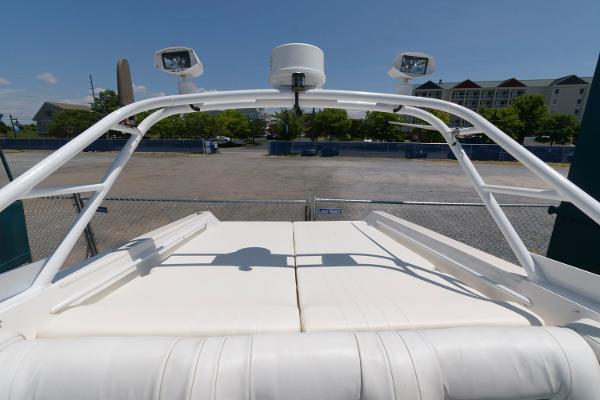 Slide: The Image of 1991 Fountain 38 Sport Cruiser with white seating and radar arch in a marina. - 9