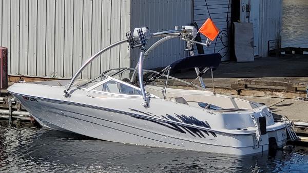Slide: The Image of 1996 Four Winns 190 Horizon Bowrider boat docked at a marina. - 2