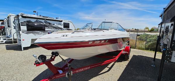 Slide: The Image of 1996 Four Winns 190 Horizon DLX boat on a red trailer in a parking lot. - 1