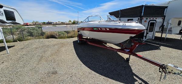 Slide: The Image of 1996 Four Winns 190 Horizon DLX boat on a trailer in a parking lot. - 2
