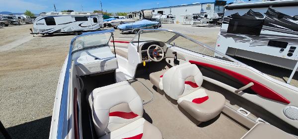 Slide: The Image of 1996 Four Winns 190 Horizon DLX boat interior with white and red seating, parked in a lot. - 5