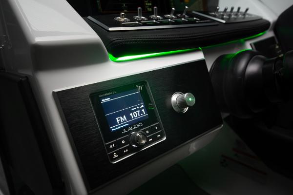 Slide: The Image of 2023 Four Winns H2 OB boat dashboard with JL Audio system and green LED lighting. - 11