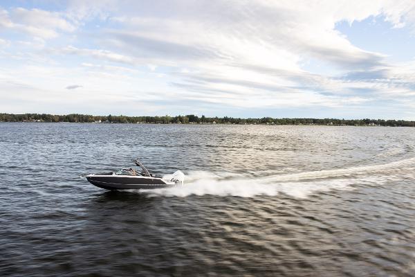 Slide: The Image of 2023 Four Winns H2 OB speedboat cruising on a lake under a partly cloudy sky. - 4