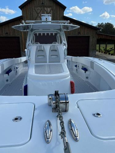 Slide: The Image of 2022 Freeman 37 VH boat with dual seating and anchor chain, docked near a wooden building. - 16