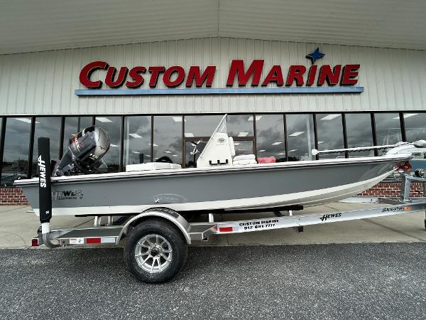 Slide: The Image of 2024 Hewes Redfisher 18 boat on trailer outside Custom Marine dealership. - 1