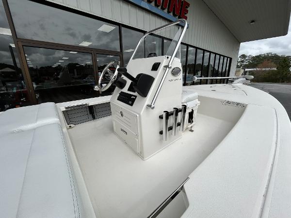 Slide: The Image of 2024 Hewes Redfisher 18 boat console and seating area outside a dealership. - 10