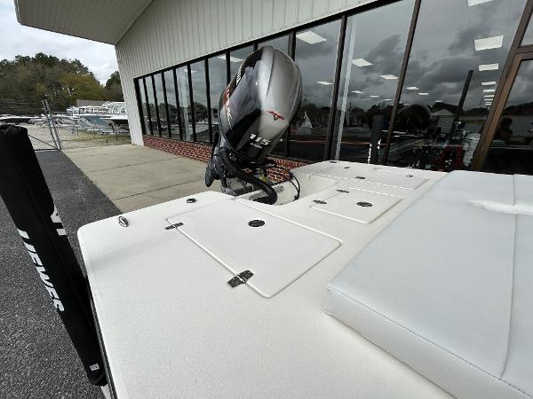Slide: The Image of 2024 Hewes Redfisher 18 boat with 115 HP engine, docked near a showroom. - 11
