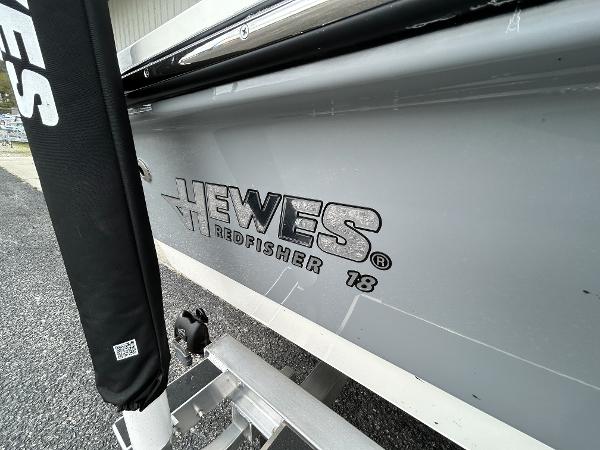 Slide: The Image of 2024 Hewes Redfisher 18 boat side view with logo. - 12