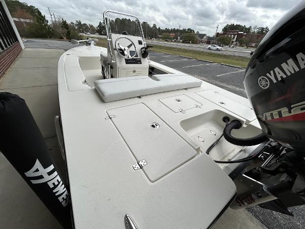 Slide: The Image of 2024 Hewes Redfisher 18 boat with Yamaha engine, docked on a cloudy day. - 19